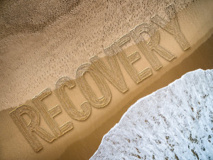 recovery written in the sand on a beach